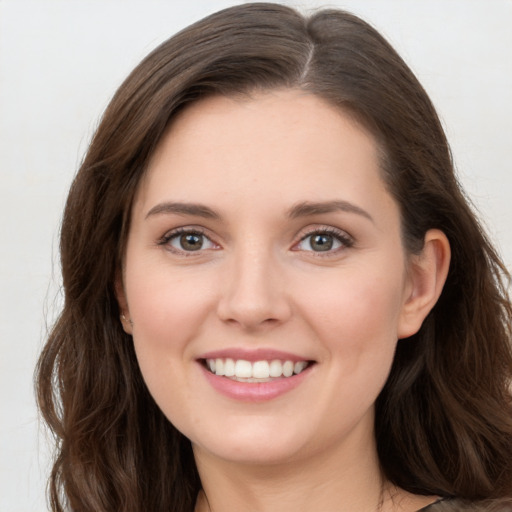 Joyful white young-adult female with long  brown hair and green eyes