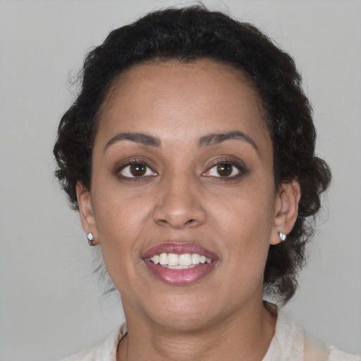 Joyful black young-adult female with medium  brown hair and brown eyes