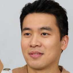 Joyful asian young-adult male with short  black hair and brown eyes