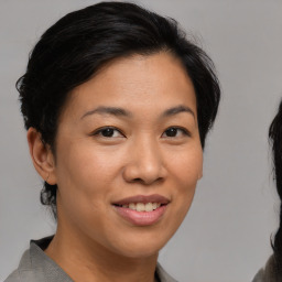 Joyful asian young-adult female with medium  brown hair and brown eyes