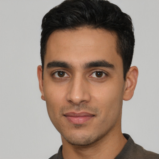 Joyful latino young-adult male with short  black hair and brown eyes