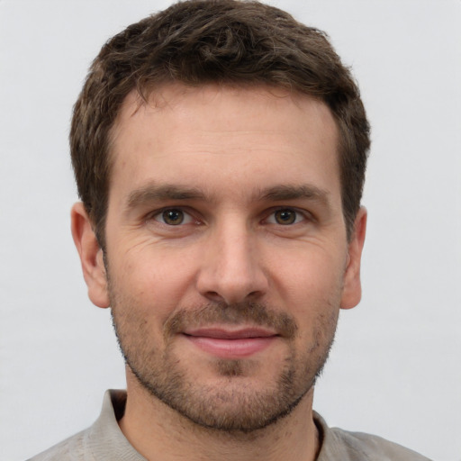 Joyful white young-adult male with short  brown hair and grey eyes