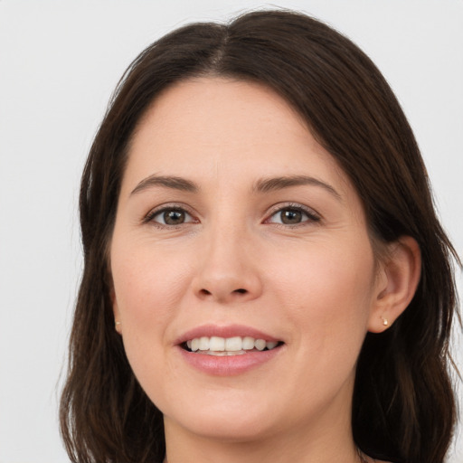 Joyful white young-adult female with long  brown hair and brown eyes