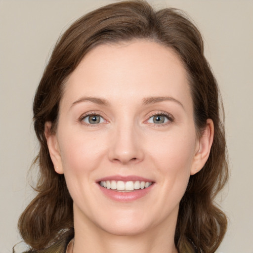 Joyful white young-adult female with medium  brown hair and green eyes