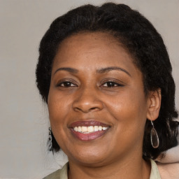 Joyful black adult female with medium  brown hair and brown eyes