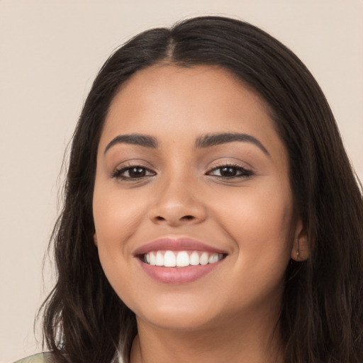 Joyful latino young-adult female with long  black hair and brown eyes