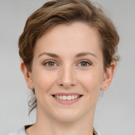 Joyful white young-adult female with medium  brown hair and grey eyes