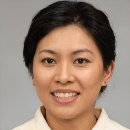 Joyful asian adult female with medium  brown hair and brown eyes