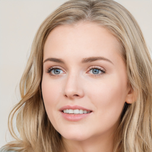 Joyful white young-adult female with long  brown hair and blue eyes