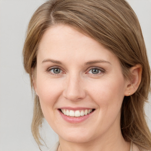 Joyful white young-adult female with medium  brown hair and grey eyes