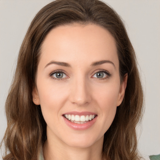 Joyful white young-adult female with long  brown hair and green eyes