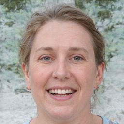 Joyful white adult female with medium  brown hair and blue eyes