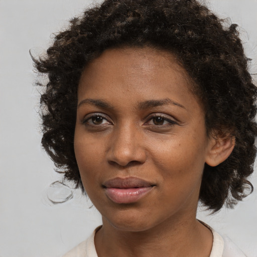 Joyful black young-adult female with medium  brown hair and brown eyes