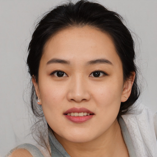 Joyful asian young-adult female with medium  brown hair and brown eyes