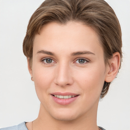 Joyful white young-adult female with short  brown hair and grey eyes