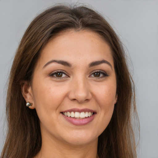 Joyful white young-adult female with long  brown hair and brown eyes