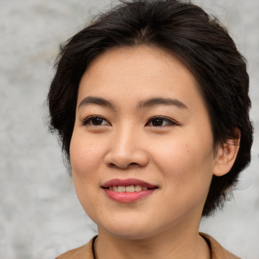 Joyful asian young-adult female with medium  brown hair and brown eyes