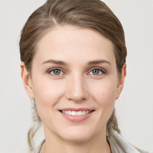 Joyful white young-adult female with medium  brown hair and grey eyes