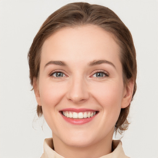 Joyful white young-adult female with medium  brown hair and grey eyes