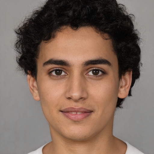 Joyful latino young-adult male with short  brown hair and brown eyes