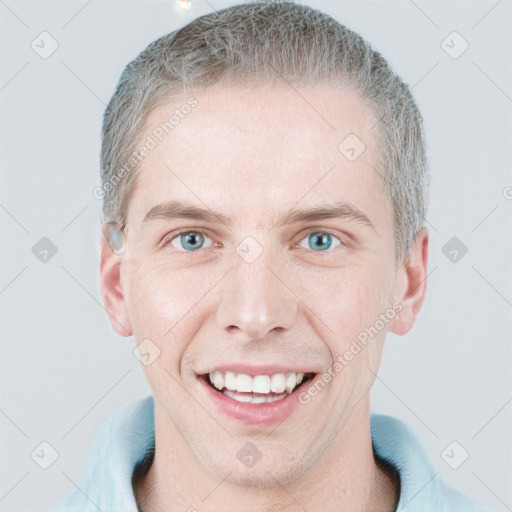 Joyful white young-adult male with short  brown hair and blue eyes