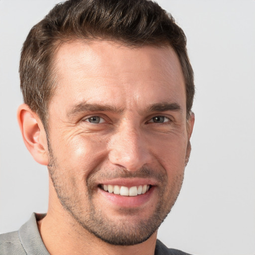 Joyful white adult male with short  brown hair and grey eyes