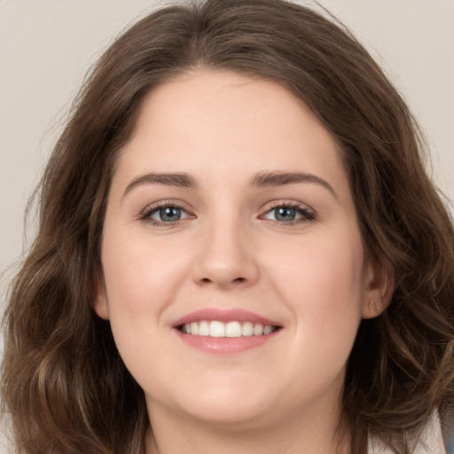 Joyful white young-adult female with long  brown hair and grey eyes