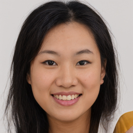 Joyful asian young-adult female with long  brown hair and brown eyes