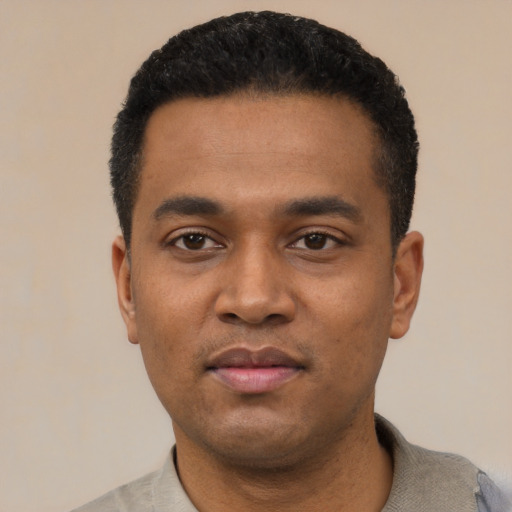 Joyful latino young-adult male with short  black hair and brown eyes