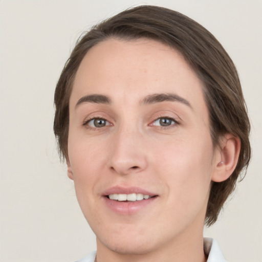 Joyful white young-adult female with medium  brown hair and grey eyes