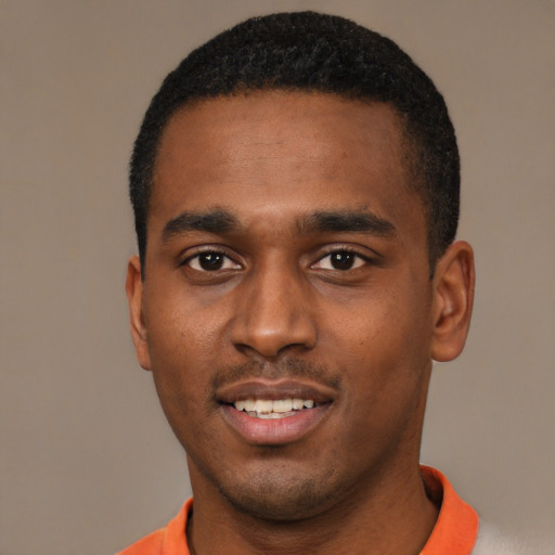Joyful black young-adult male with short  black hair and brown eyes
