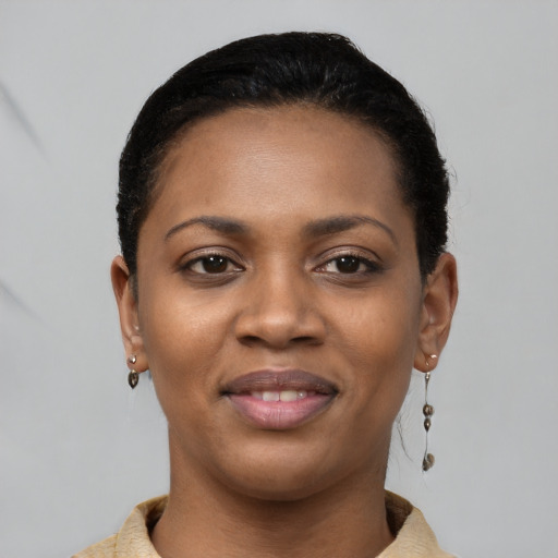 Joyful black young-adult female with short  black hair and brown eyes