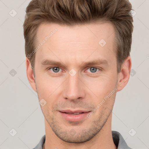 Joyful white young-adult male with short  brown hair and grey eyes