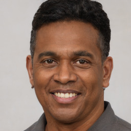 Joyful latino adult male with short  black hair and brown eyes