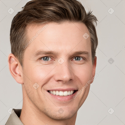 Joyful white young-adult male with short  brown hair and grey eyes