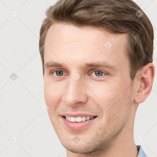 Joyful white young-adult male with short  brown hair and grey eyes