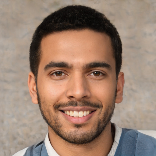 Joyful latino young-adult male with short  brown hair and brown eyes