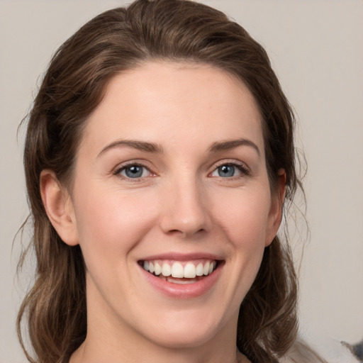 Joyful white young-adult female with medium  brown hair and grey eyes