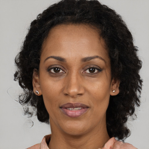 Joyful black adult female with medium  brown hair and brown eyes