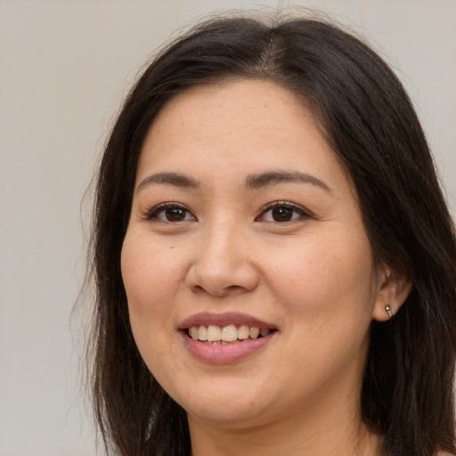 Joyful asian young-adult female with long  brown hair and brown eyes