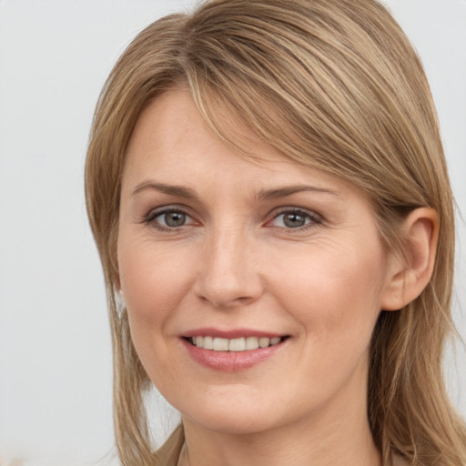 Joyful white young-adult female with medium  brown hair and grey eyes