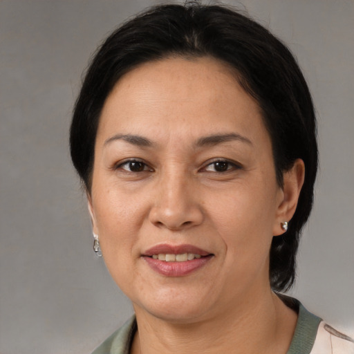 Joyful latino adult female with medium  brown hair and brown eyes