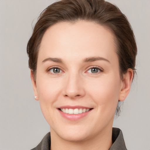 Joyful white young-adult female with short  brown hair and grey eyes