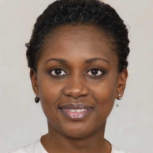 Joyful black young-adult female with short  black hair and brown eyes