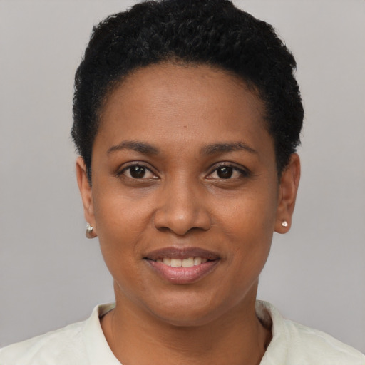 Joyful black young-adult female with short  black hair and brown eyes