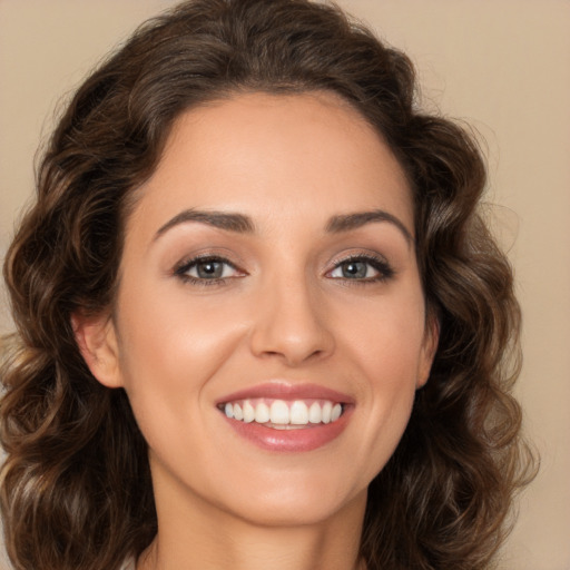 Joyful white young-adult female with long  brown hair and brown eyes