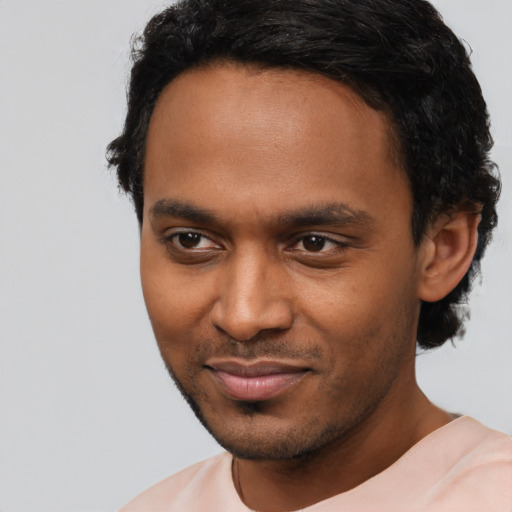 Joyful black young-adult male with short  black hair and brown eyes