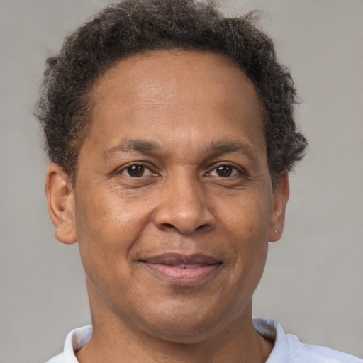 Joyful black adult male with short  brown hair and brown eyes