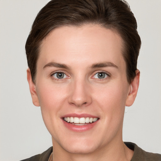 Joyful white young-adult female with short  brown hair and grey eyes