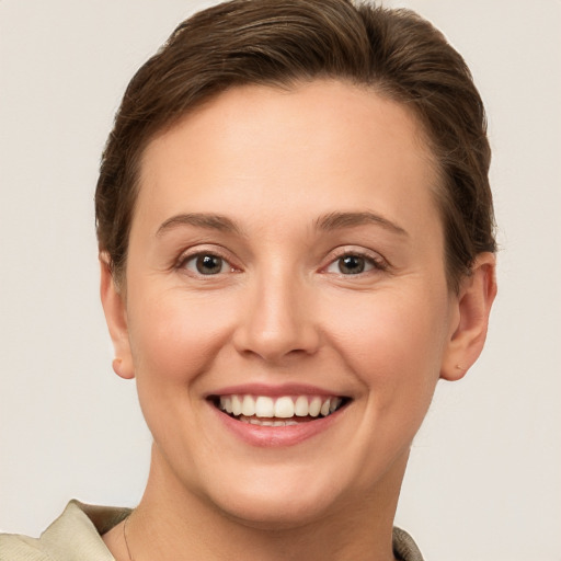 Joyful white young-adult female with short  brown hair and grey eyes